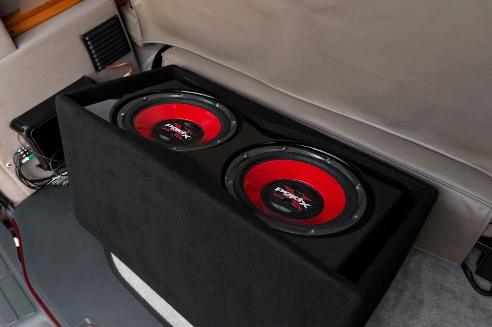 interiorul unei camionete chevrolet express, arătând o pereche de subwoofere aftermarket